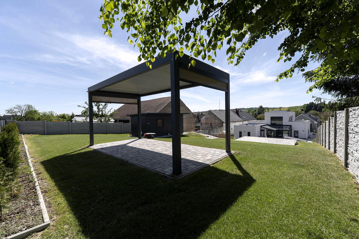 Pergola a vzrostlá zeleň v zahradě
