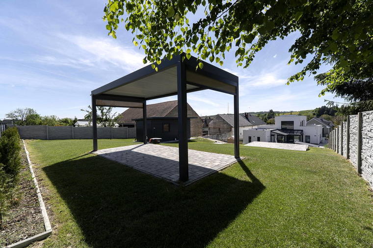 Pergola a vzrostlá zeleň v zahradě